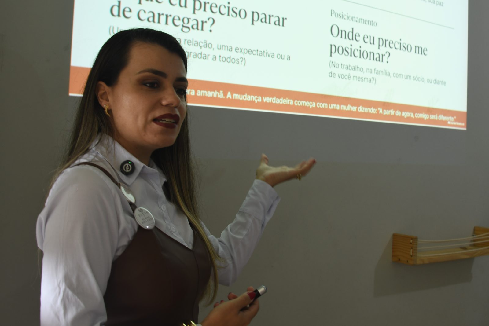 Amanda Simeão em palestra, gesticulando diante do slide